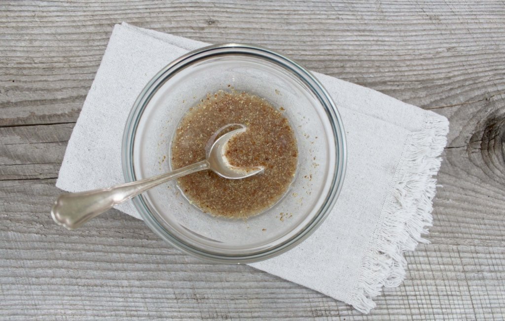 mix flaxseed egg mixture, the flaxseed mixture in a clear bowl with a spoon in it