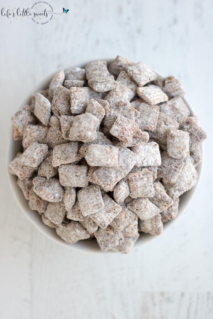 Nutella Muddy Buddies in a white bowl on a white wood surface