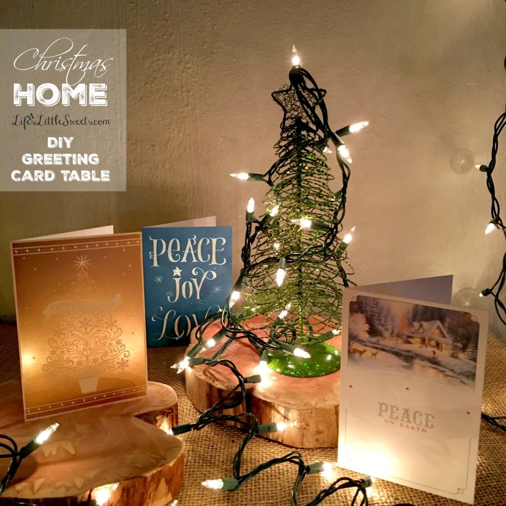 DIY Christmas Garland and Greeting Card Table on a white wall close up of table