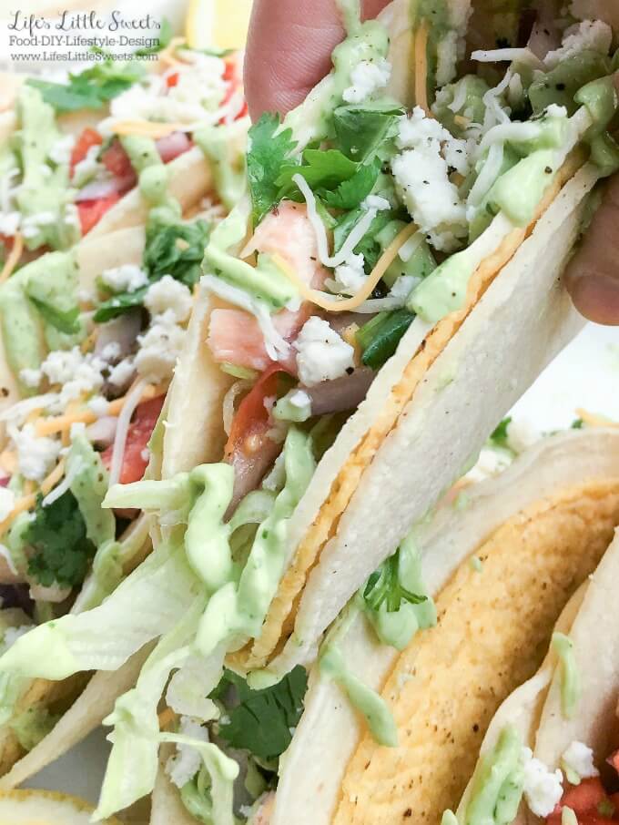 Salmon Tacos with Fresh Salsa and Avocado Sauce - These Salmon Tacos have homemade fresh salsa and a cilantro avocado sauce which will thrill your taste buds. This delicious and satisfying recipe is perfect for game day or a family dinner! #taco #avocadosauce #salsa #citrus #lemon #salmon #tortillas #cheese #lettuce #cabbage