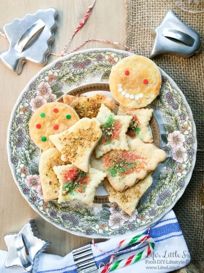 Sand tart cookies on a holiday plate overhead, with antique metal cookie cutters