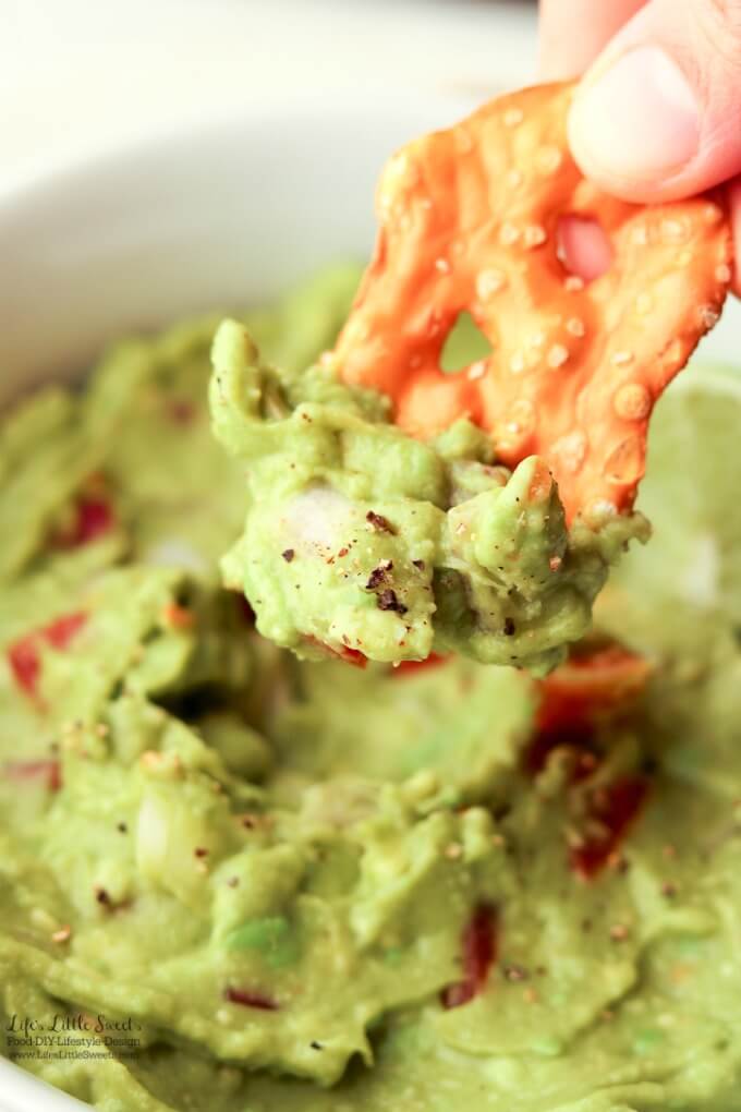 A delicious bite | This Easy Guacamole is fresh and a perfect recipe for Spring and Summer. A simple recipe with red onions, fresh chopped tomatoes and a spritz of lime, enjoy it for any gathering, game day or a quick snack for yourself!