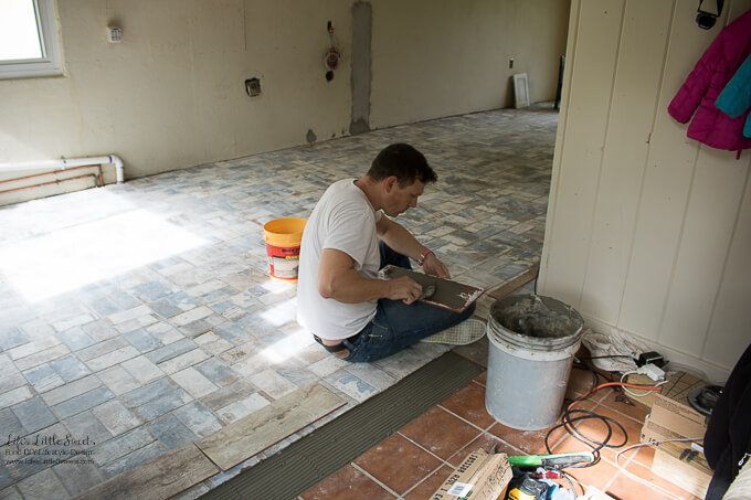 29. Eric working on the threshold with new wood printed tiles to reflect the wood beams in the ceiling | Kitchen Renovation New Tile Floor – Check out the latest from the Life’s Little Sweets home kitchen renovation being our tile floor odyssey this past week (and other updates with 45 photos!)