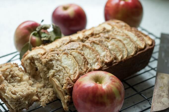 Homemade Apple Quick Bread on a cooling rack with fresh apples