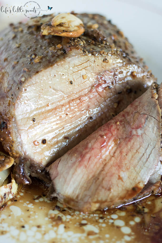 This Garlic Herb Eye of the Round Roast is a savory, flavorful and meaty main dish for the dinner table. This roast is seasoned with fresh herbs like thyme, rosemary and garlic, onions and Montreal Steak Seasoning. Easy to make for a weeknight or holiday dinner alike.  (gluten-free) #glutenfree #roast #eyeoftheround #thyme #rosemary #Montrealsteakseasoning #garlic