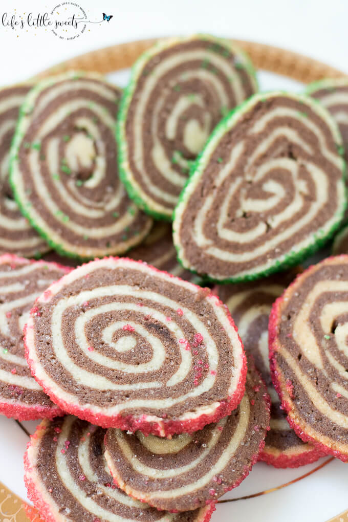 Pinwheel Cookies are perfect for the Christmas holiday season; this family recipe has a dough that can be made ahead and then sliced when ready to make them. They are crisp sugar cookies with alternating vanilla and chocolate dough, and optionally coated in festive sugar sprinkles. #sprinkles #sugarcookies #cookies #christmascookies #holiday #chocolate #christmas #pinwheels #pinwheelcookies #recipe