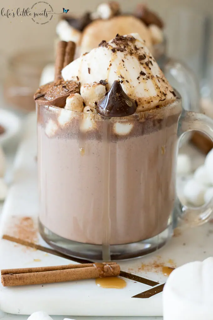 This Epic Slow Cooker Hot Chocolate is waiting for you and warms you up when you come in from the cold. It has decadent chocolate flavor, topped with marshmallows, shaved chocolate, cinnamon sticks, caramel syrup & chocolate candies. #marshmallows #hotchocolate #slowcooker #crockpot #cinnamon #cinnamonstick #Saigoncinnamon #darkchocolate #caramel #caramelsauce #homemade 