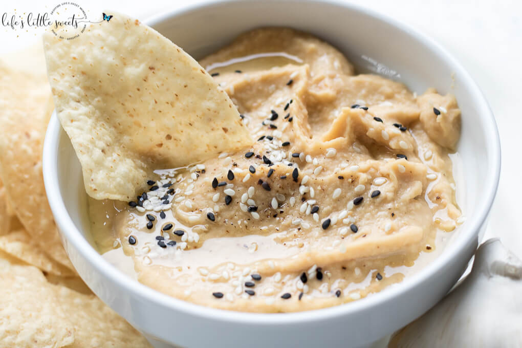 This Fresh Garlic Hummus takes minutes to make with simple ingredients like chickpeas, fresh garlic, tahini, olive oil, salt and pepper - savory, fresh and delicious, serve it with tortilla chips, tortillas, bread, or in sandwiches! (vegan, gluten-free, video) #vegan #glutenfree #tahini #hummus #homemade #recipe #sesameseeds #oliveoil #chickpeas #salt #pepper