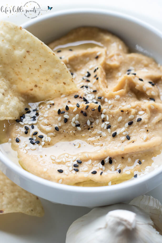 This Fresh Garlic Hummus takes minutes to make with simple ingredients like chickpeas, fresh garlic, tahini, olive oil, salt and pepper - savory, fresh and delicious, serve it with tortilla chips, tortillas, bread, or in sandwiches! (vegan, gluten-free, video) #vegan #glutenfree #tahini #hummus #homemade #recipe #sesameseeds #oliveoil #chickpeas #salt #pepper