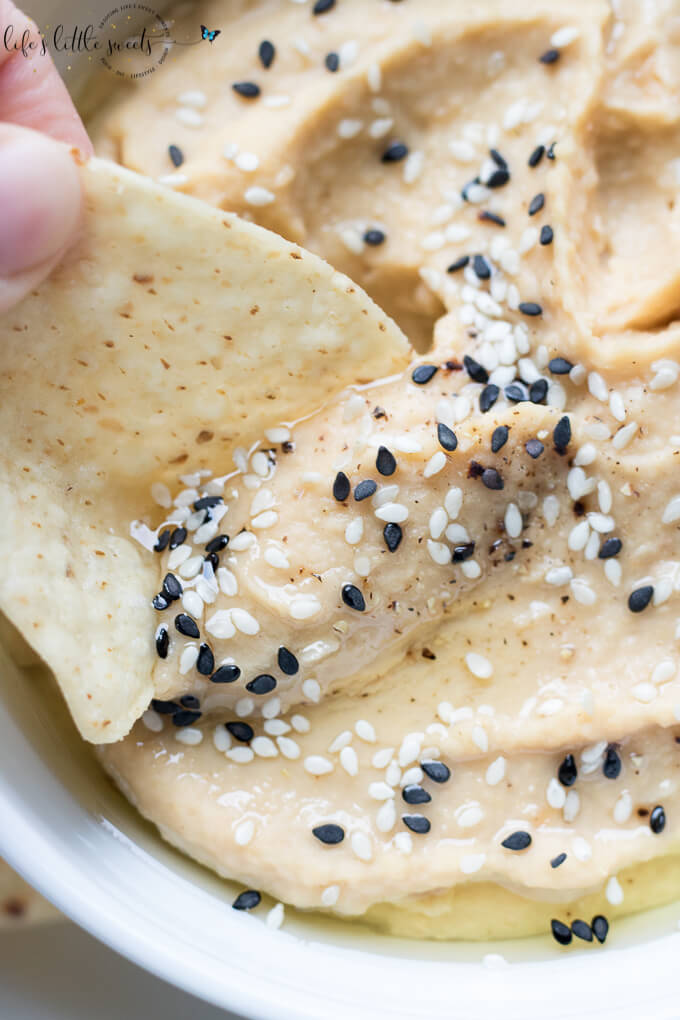 This Fresh Garlic Hummus takes minutes to make with simple ingredients like chickpeas, fresh garlic, tahini, olive oil, salt and pepper - savory, fresh and delicious, serve it with tortilla chips, tortillas, bread, or in sandwiches! (vegan, gluten-free, video) #vegan #glutenfree #tahini #hummus #homemade #recipe #sesameseeds #oliveoil #chickpeas #salt #pepper