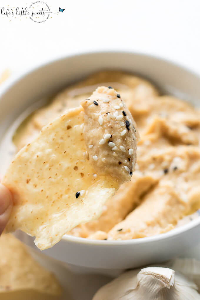 This Fresh Garlic Hummus takes minutes to make with simple ingredients like chickpeas, fresh garlic, tahini, olive oil, salt and pepper - savory, fresh and delicious, serve it with tortilla chips, tortillas, bread, or in sandwiches! (vegan, gluten-free, video) #vegan #glutenfree #tahini #hummus #homemade #recipe #sesameseeds #oliveoil #chickpeas #salt #pepper