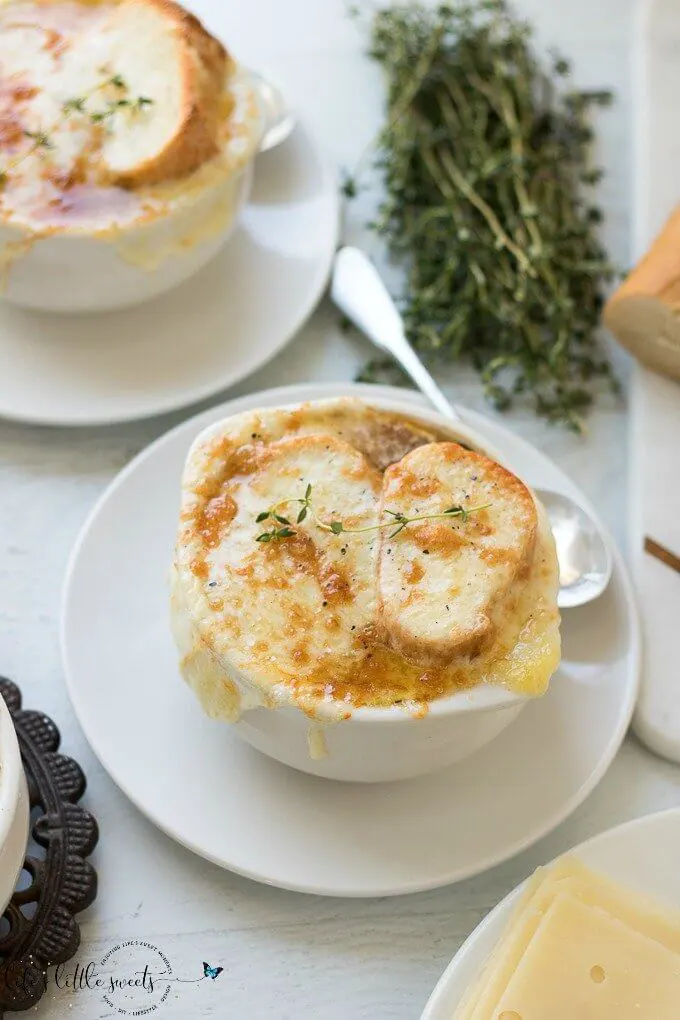 This Homemade French Onion Soup recipe has the flavors of a classic French onion soup that you would find at a restaurant, yet, it is easy to prepare in your home kitchen. Caramelized onions in a reduction of white wine and sherry with herbs of thyme and bay leaves in a clear beef broth make this soup delicious. #onions #Frenchonionsoup #cheese #recipe #Frenchbread #homemade #thyme #garlic #Muentser #Swiss