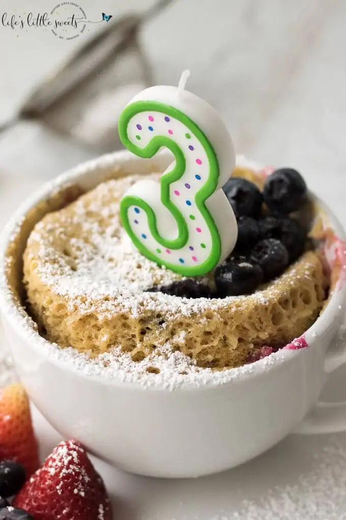 3 candle on top of a mug cake