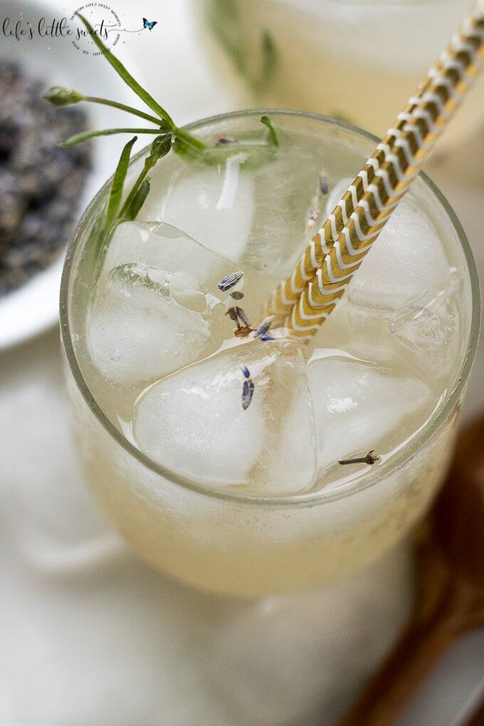 This Lavender Lemonade is made with freshly squeezed lemon juice then sweetened with a lavender-infused simple syrup. Garnish with food grade dried lavender flowers and a sprig of fresh lavender and you have yourself the ideal summer sipper! This recipe uses Lavender Simple Syrup. #lavender #lavenderlemonade #lemonade #driedlavender #iced #drink #colddrink #Summerdrink #vegan #glutenfree