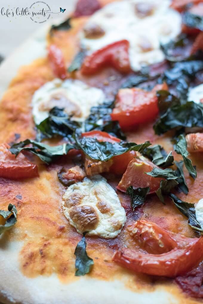 This Caprese Pizza is topped with ripe tomatoes, fresh basil, sliced mozzarella and drizzled with an olive oil-balsamic dressing. Make this homemade pizza for a bistro dinner at home! (makes 2 individual pizzas or 1 large pizza) #tomato #basil #pizza #homemade #recipe #mozzarella