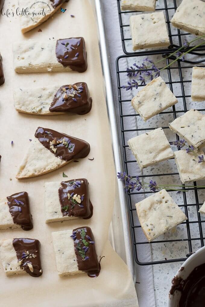 This Lavender Shortbread has fresh lavender, mint and lemon zest. Top with chopped nuts, like pecans, and dip in melted semi sweet chocolate, if you like. Welcome Summer with all it's fresh ingredients in this classic shortbread recipe. #lavender #mint #shortbread #freshlavender #lemon #lemonzest #pecans #cookies #chocolate #chocolatedipped