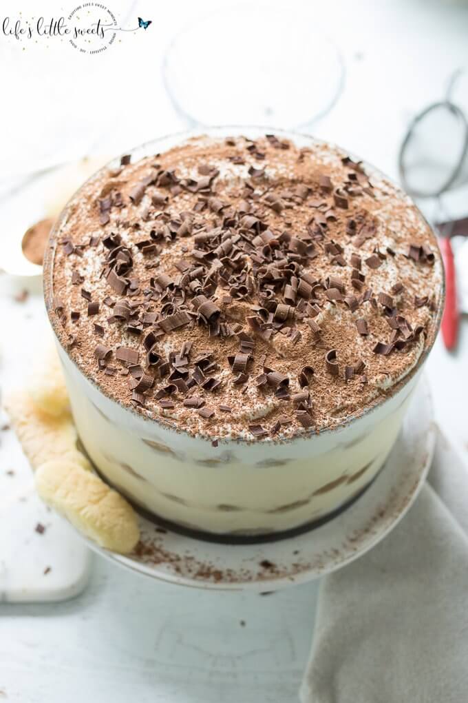 This Tiramisu Trifle has delicate ladyfinger sponge cakes soaked in an espresso-rum mixture, layered with a rich Mascarpone-whipped cream mixture and topped with vanilla whipped cream, cocoa powder and semi sweet chocolate curls. #tiramisutrifle #trifle #dessert #espresso #tiramisu #trifle #chocolate #Mascarpone #ladyfingers