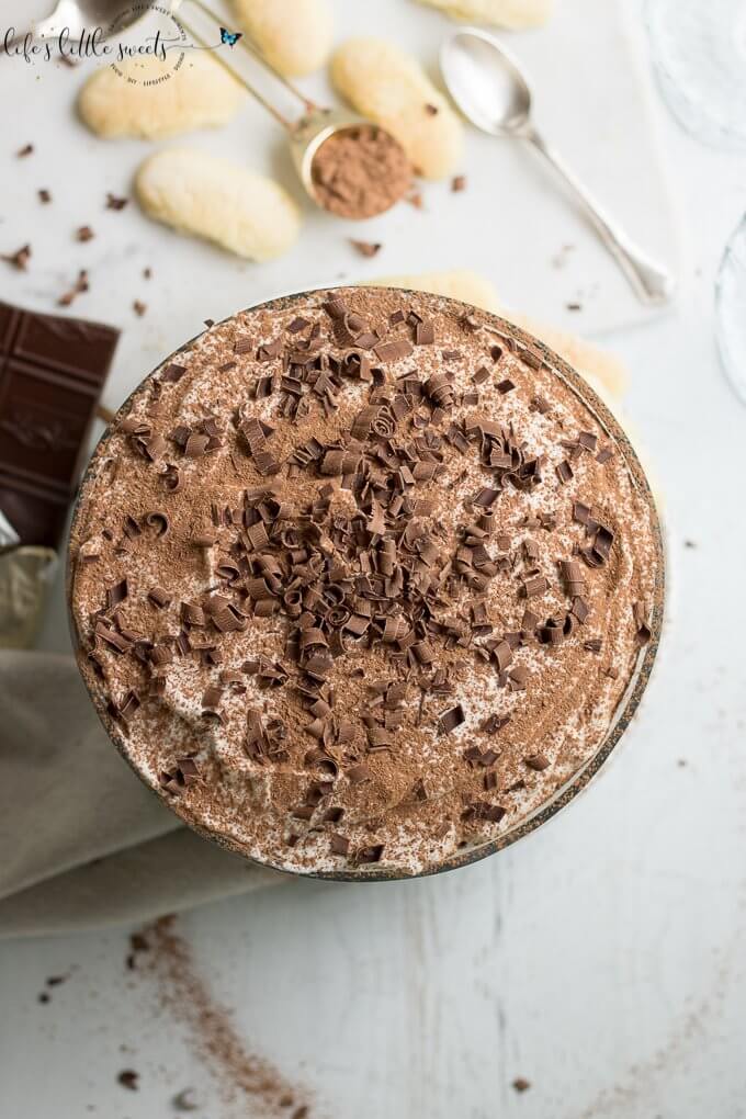 This Tiramisu Trifle has delicate ladyfinger sponge cakes soaked in an espresso-rum mixture, layered with a rich Mascarpone-whipped cream mixture and topped with vanilla whipped cream, cocoa powder and semi sweet chocolate curls. #tiramisutrifle #trifle #dessert #espresso #tiramisu #trifle #chocolate #Mascarpone #ladyfingers