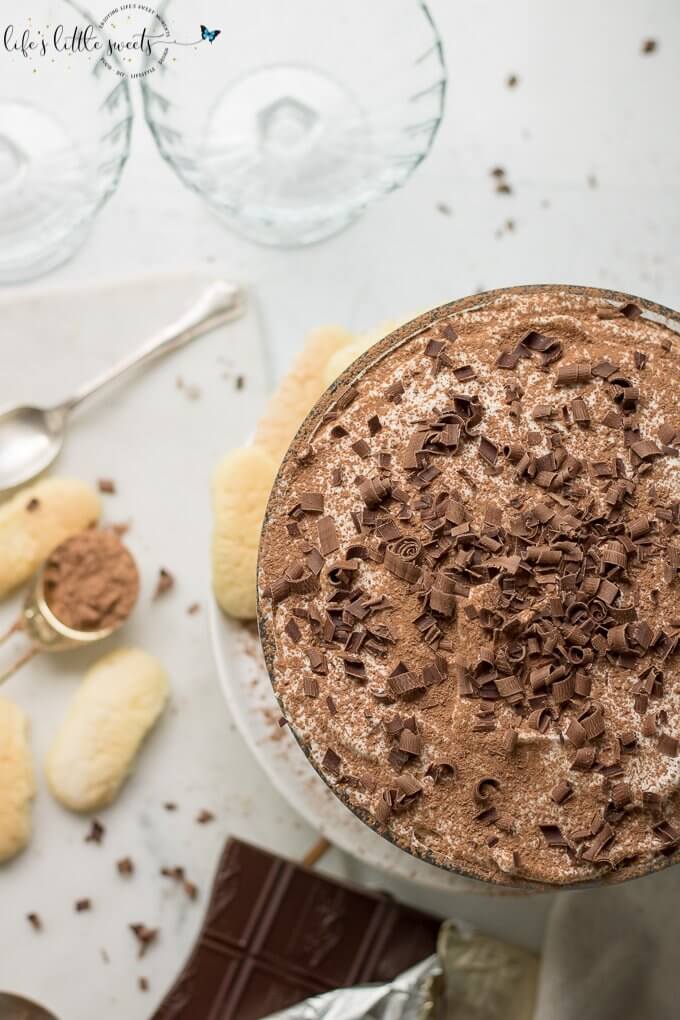 This Tiramisu Trifle has delicate ladyfinger sponge cakes soaked in an espresso-rum mixture, layered with a rich Mascarpone-whipped cream mixture and topped with vanilla whipped cream, cocoa powder and semi sweet chocolate curls. #tiramisutrifle #trifle #dessert #espresso #tiramisu #trifle #chocolate #Mascarpone #ladyfingers