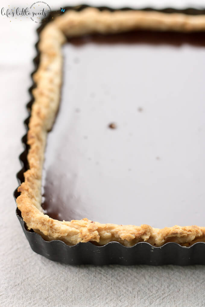 This Ganache Tart recipe is easy yet decadent with a homemade almond (or plain) and butter tart crust and smooth homemade chocolate ganache. #dessert #ganache #chocolate #tart #ganacetart