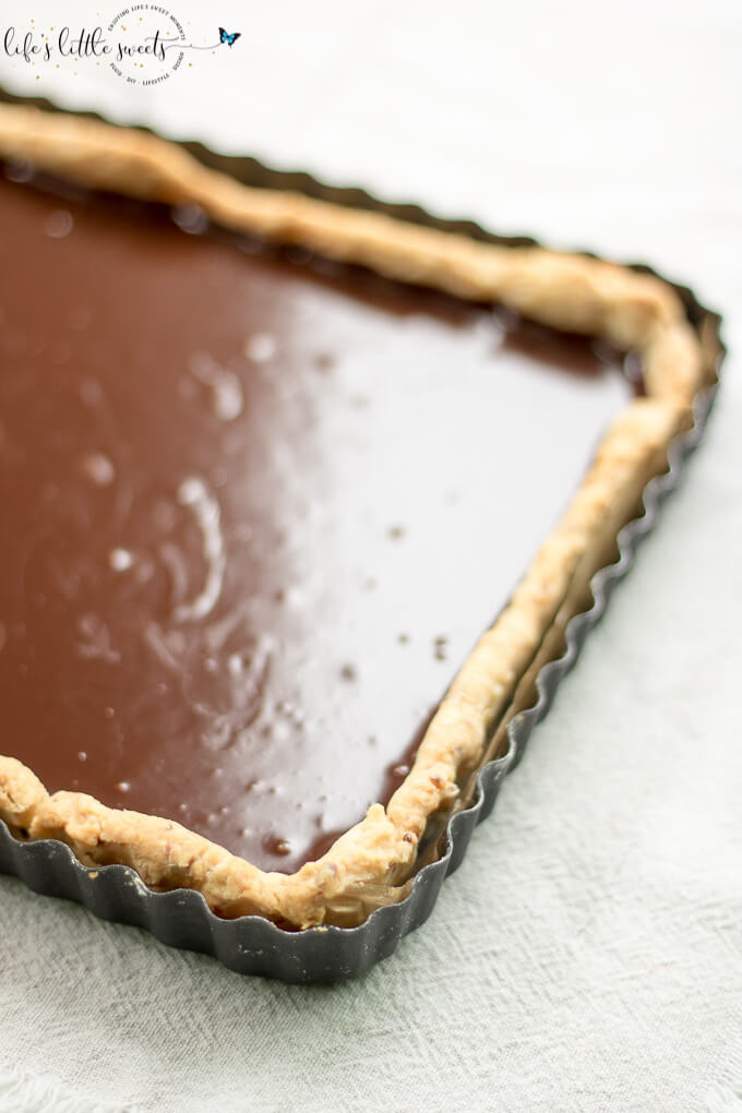 This Ganache Tart recipe is easy yet decadent with a homemade almond (or plain) and butter tart crust and smooth homemade chocolate ganache. #dessert #ganache #chocolate #tart #ganacetart