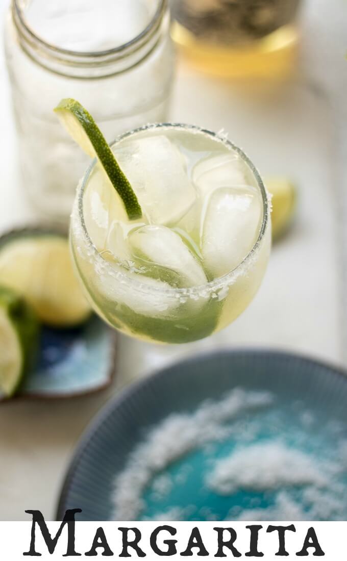 (msg 21+) This classic, Margarita recipe tastes like Summer with fresh lime juice, margarita mixer, tequila and served in a chilled glass, rimmed with Mediterranean salt crystals and lime slices. #lime #margarita #seasalt #ice #drink