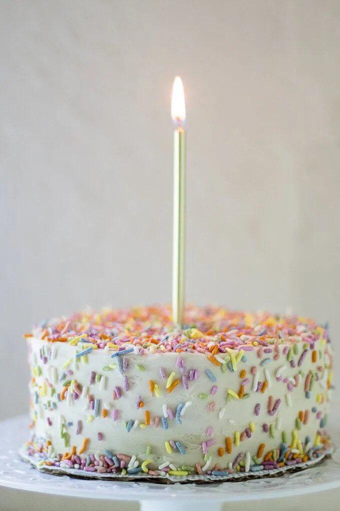 This 1st Birthday Cake recipe has 2 tiers, 5-inch diameter layers of delicious banana bread cake with a cream cheese frosting - all naturally-sweetened of course :) Top with all natural sprinkles for the cutest 1st Birthday cake ever! (gluten-free option) #cake #bananabread #1stbirthdaycake #naturallysweetened #maplesyrup #creamcheesefrosting #bananacake #birthdaycake #birthday #recipe