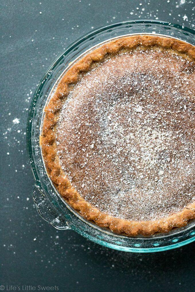 This Chess Pie recipe is a simple, solid, sweet pie recipe topped with confectioner's sugar, a sprinkling of crushed sea salt. It has a distinctive yellow batter which is thickened with corn meal. Bring to a holiday gathering, potluck or make it for an easy dessert after a weeknight meal. Serve it cold or warm and enjoy this delicious pie with a hot cup of coffee! (makes 1, 9-inch pie) #pie #chesspie #dessert #sweet #sugar #cornmeal #confectionerssugar