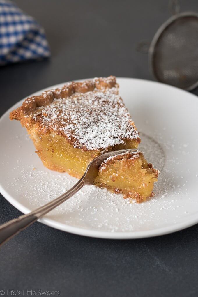 This Chess Pie recipe is a simple, solid, sweet pie recipe topped with confectioner's sugar, a sprinkling of crushed sea salt. It has a distinctive yellow batter which is thickened with corn meal. Bring to a holiday gathering, potluck or make it for an easy dessert after a weeknight meal. Serve it cold or warm and enjoy this delicious pie with a hot cup of coffee! (makes 1, 9-inch pie) #pie #chesspie #dessert #sweet #sugar #cornmeal #confectionerssugar