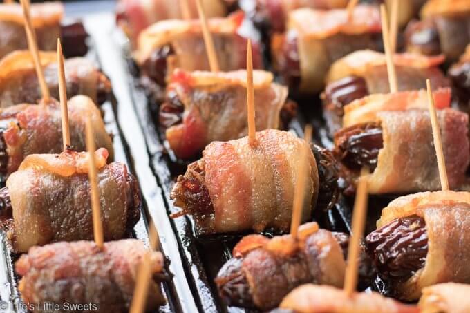 Bacon Wrapped Stuffed Dates are a savory-sweet appetizer or snack, served hot, perfect for having at a gathering. Pitted Medjool dates stuffed with soft cheese like Blue or Stilton Cheese, then wrapped with thick-sliced bacon and baked on a cast iron grill pan (or rimmed baking sheet). They are so delicious and mouthwatering that you can never have just one! #bacon #recipe #dates #Stilton #stuffeddates #hotappetizers #appetizers #gameday #Christmasfood #christmas