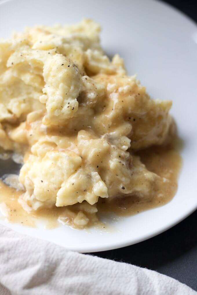These Creamy Traditional Mashed Potatoes are rich, smooth and delicious topped with butter and optional gravy. They make a terrific holiday side dish or for whenever you crave a solid mashed potatoes recipe! #mashedpotatoes #recipe #YukonGold #potatoes #creamy #traditional #butter