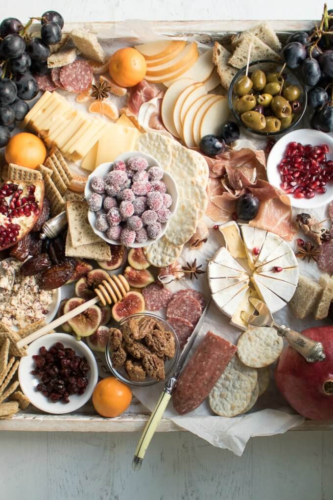 Learn how to make an Epic Charcuterie Board for impressive yet easy entertaining. This Winter Charcuterie Board is filled with meats, cheeses, veggies, nuts, olives, dried fruits, crackers, and more. An easy appetizer perfect for happy hour entertaining. #charcuterie #board #appetizers #newyears #cheese #olives #ad #sofabfood @sofabfood