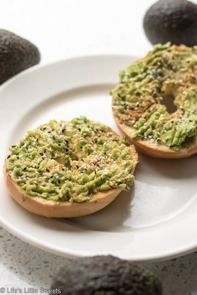 Avocado Bagel Toast with avocados in the background