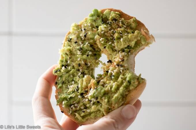 Avocado Bagel Toast being held by a hand