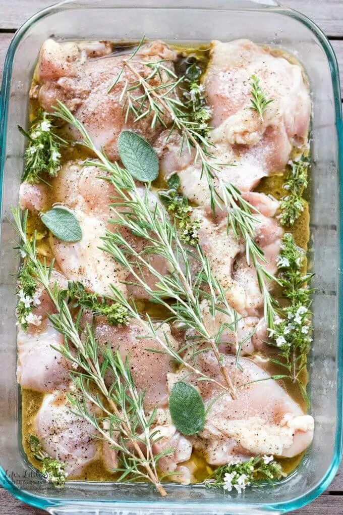 raw chicken thighs with fresh herbs and marinade