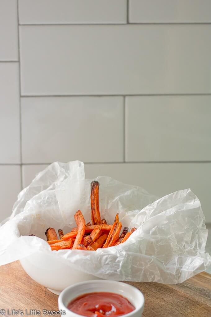 Air Fryer Carrot Fries have ground cumin, smoked paprika, kosher salt and fresh ground pepper with a small amount of Canola oil. This is a more healthy version of carrot fries with less oil using an Air Fryer. This easy recipe only requires 7 ingredients and 15 minutes! (gluten free, vegan) #ad #carrots #carrot #fries #airfried #airfryer #easy #airfryercarrotfries #savory #recipe #cumin #paprika #salt #pepper