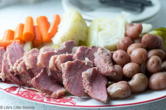 Corned Beef and Cabbage is a classic Irish-American family dinner popular to serve on St. Patrick's Day. This savory, delicious and complete meal is cooked in a Dutch Oven on the stove top with corned beef brisket, baby red potatoes, green cabbage wedges and carrots. #cornedbeefandcabbage #stpatricksday #carrots #redpotatoes #recipe #greencabbage #cabbage #Dutchoven #brisket