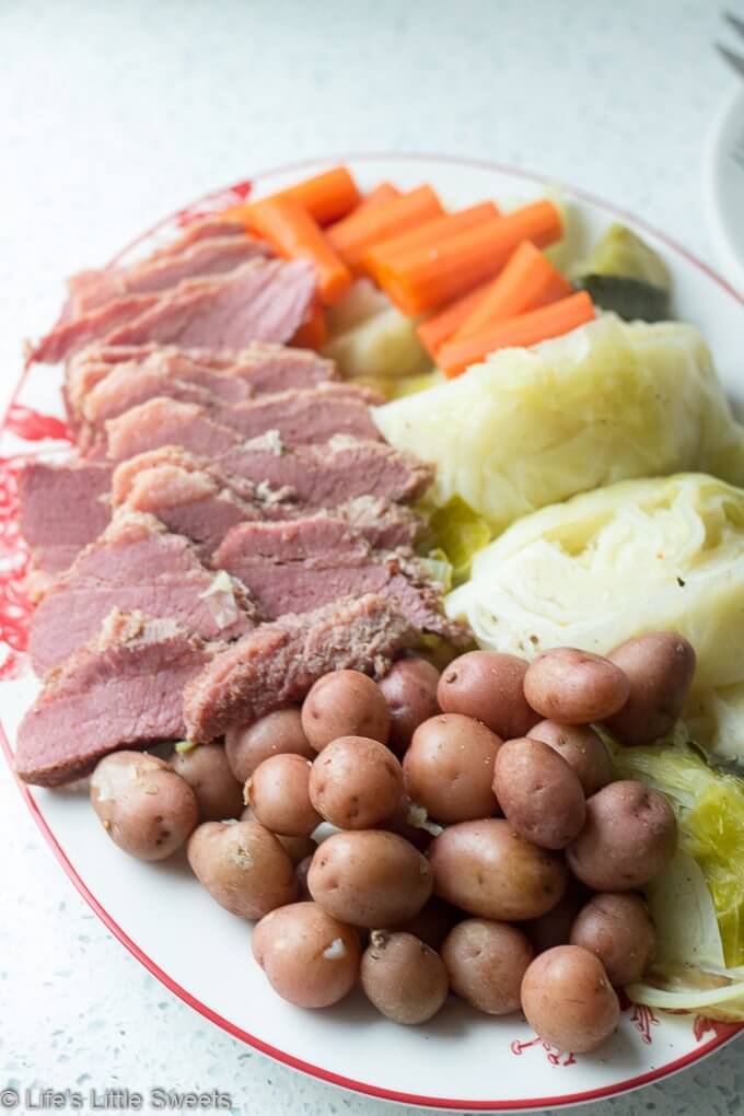 Corned Beef and Cabbage is a classic Irish-American family dinner popular to serve on St. Patrick's Day. This savory, delicious and complete meal is cooked in a Dutch Oven on the stove top with corned beef brisket, baby red potatoes, green cabbage wedges and carrots. #cornedbeefandcabbage #stpatricksday #carrots #redpotatoes #recipe #greencabbage #cabbage #Dutchoven #brisket
