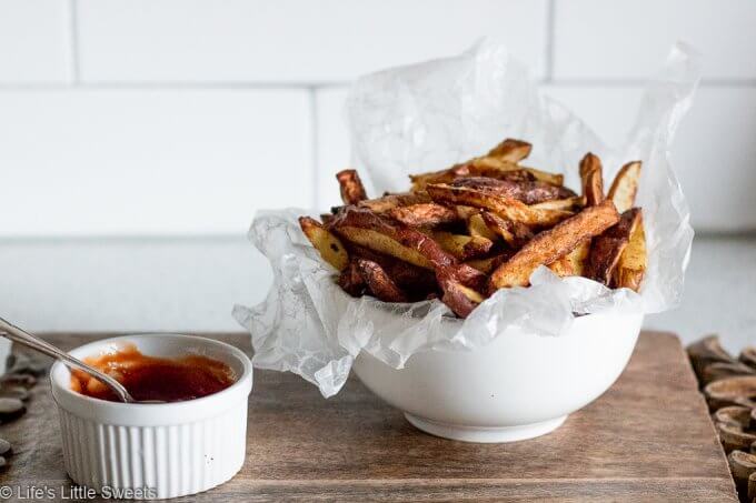 French Fries in a white bowl with ketchup