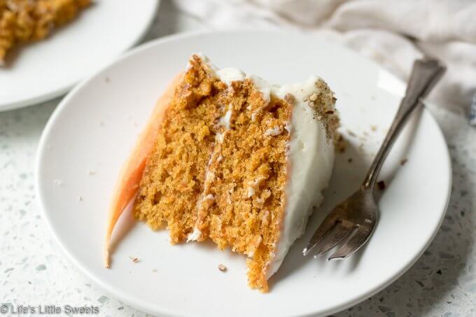 Homemade Classic Carrot Cake with Cream Cheese Frosting has cinnamon, vanilla and 3 cups of finely shredded carrots throughout this delicious cake. It is a 2-tiered cake with smooth and sweet homemade cream cheese frosting. It's topped with optional chopped pecans and decorated with fresh, peeled little carrots. #carrotcake #Eastercake #Easterfood #carrot #carrots #dessert #pecans #sweet