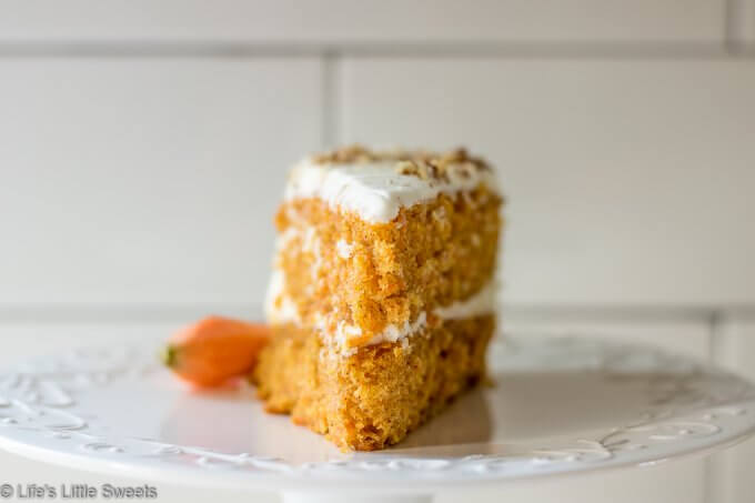 Homemade Classic Carrot Cake with Cream Cheese Frosting has cinnamon, vanilla and 3 cups of finely shredded carrots throughout this delicious cake. It is a 2-tiered cake with smooth and sweet homemade cream cheese frosting. It's topped with optional chopped pecans and decorated with fresh, peeled little carrots. #carrotcake #Eastercake #Easterfood #carrot #carrots #dessert #pecans #sweet