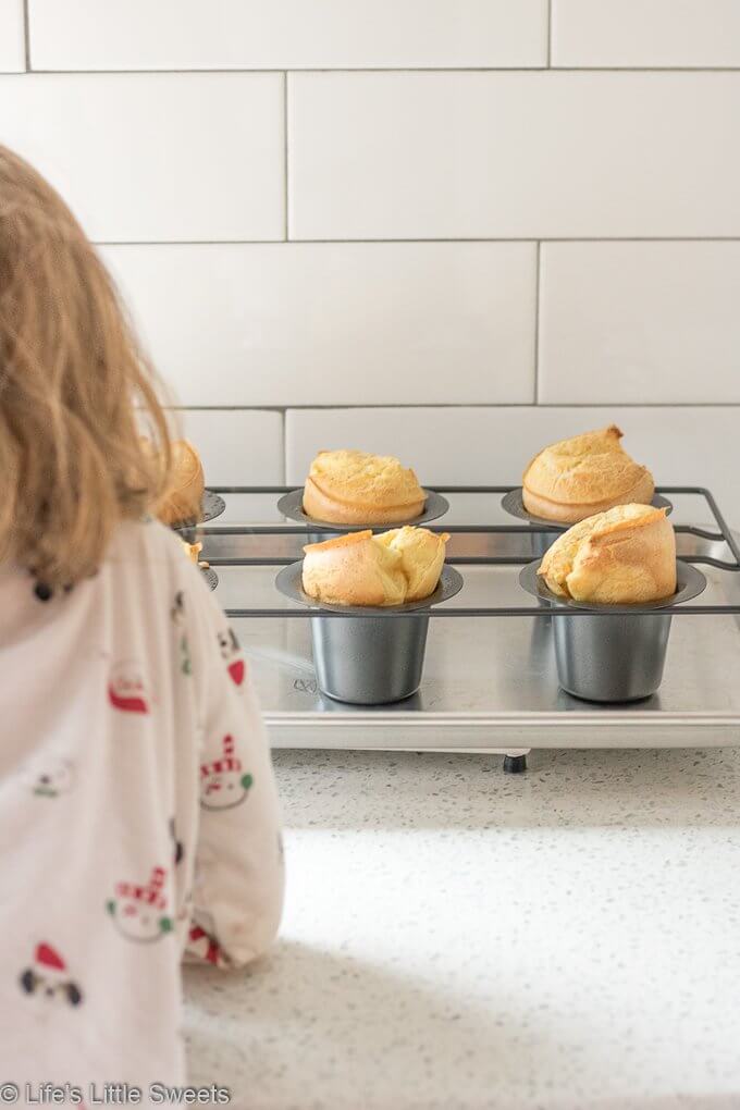 Popovers are an American bread recipe made of an egg and flour-based batter baked in individual molds. Also, known as the “American Yorkshire Pudding,” this recipe dates back to 1850. They can be served any time of the day and are delicious when eaten fresh and topped with Maple Cinnamon Butter. Popovers recipe! #popovers #recipe #homemade #appetizer #bread #eggs
