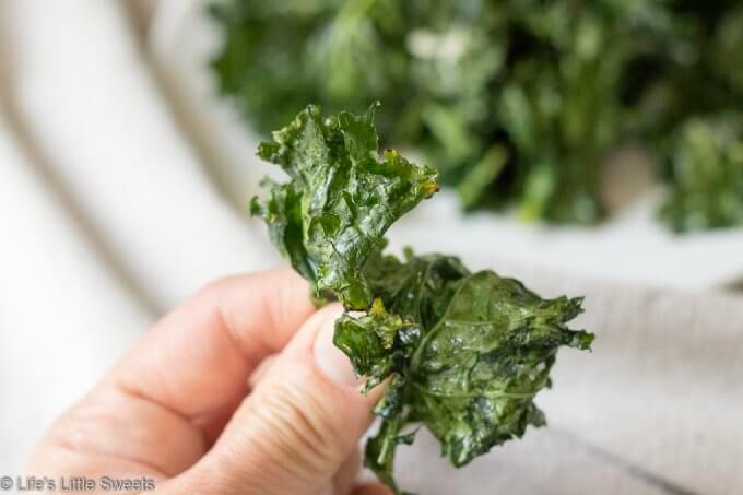 How to Make Kale Chips - hand holding a kale chip