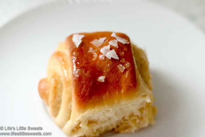 This Parker House Rolls recipe has Maple Butter and Flakey Mediterranean Sea Salt sprinkled on top. These sweet-savory rolls are a solid yeast, bread roll recipe for any occasion or holiday. #parkerhouserolls #bread #rolls #maplebutter #seasalt #dinnerrolls #butter #bread lifeslittlesweets.com