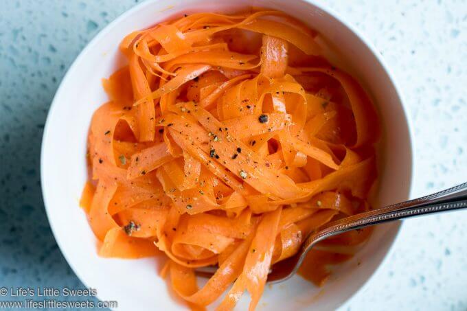 Carrot Ribbon Salad with pepper and a fork in a white bowl