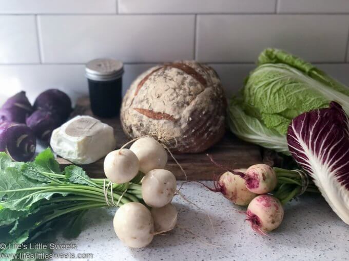 root vegetables on the counter with sourdough bread and cheese