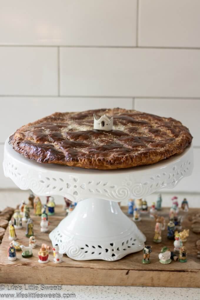 Galette Des Rois (King Cake) on a cake stand with several feves 
