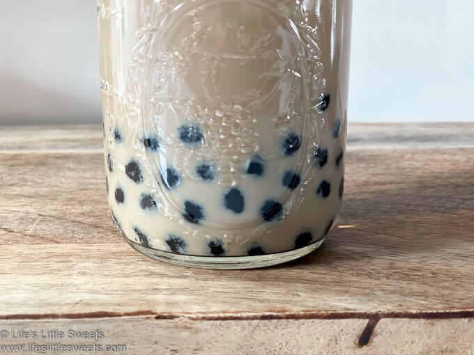 closeup of mason jar with tapioca pearls boba in the bottom 