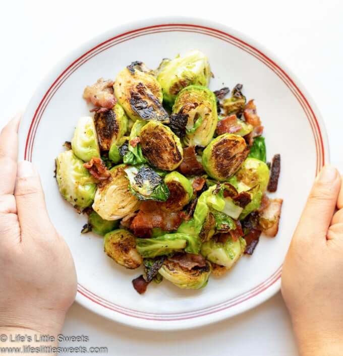 Pan-Fried Bacon Brussels Sprouts on a white plate with red stripes and white background