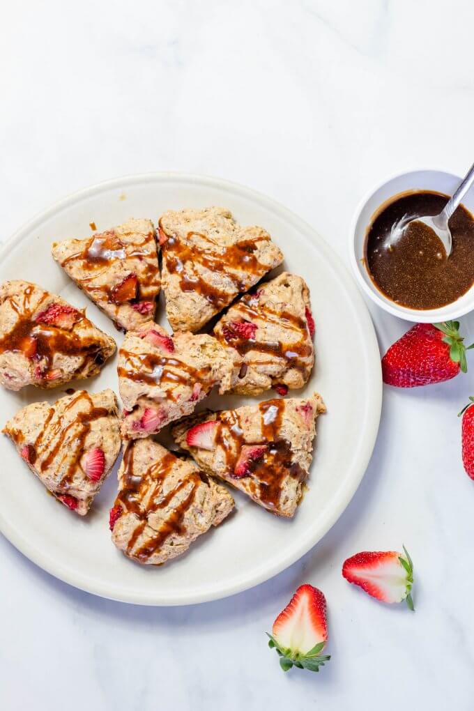 Vegan Soft Strawberry Scones on a white plate with coconut caramel sauce next to it